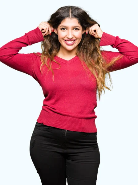Young Beautiful Woman Wearing Red Sweater Smiling Pulling Ears Fingers — Stock Photo, Image