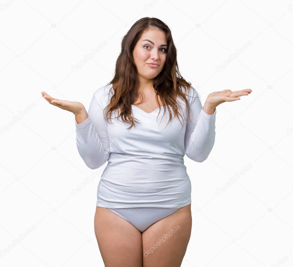 Beautiful plus size young overwight woman wearing white underwear over isolated background clueless and confused expression with arms and hands raised. Doubt concept.
