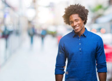 Seksi bir ifadeyle, neşeli ve mutlu yüzünü kameraya bakarak göz kırpıyor izole arka plan üzerinde Afro Amerikalı adam.