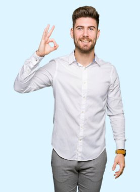 El ve parmak ile ok işareti yapıyor olumlu gülümseyen genç yakışıklı iş adamı. Başarılı ifade.