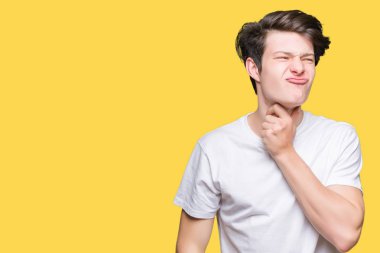 Yakışıklı delikanlı üzerinde rahat beyaz t-shirt giyen izole arka plan ağrılı boyun, boğaz gribi, kesek ve enfeksiyon için dokunaklı