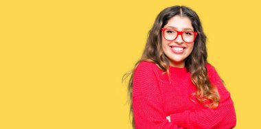 Kırmızı gözlük mutlu yüz ile gülümseyen giyen genç güzel kadın silah kameraya bakarak geçti. Olumlu bir kişi.