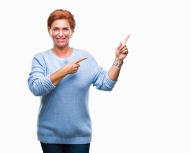 Atrractive üst düzey beyaz Kızıl saçlı kadın gülümseyerek ve iki elleri ve parmakları ile tarafına işaret kamera bakarak izole arka plan.