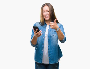 Genç güzel beyaz kadın manifatura ok işareti, başparmak ile parmak, mükemmel işareti yapıyor kocaman bir gülümseme ile izole arka plan üzerinde mutlu Smartphone kullanarak ileti gönderme