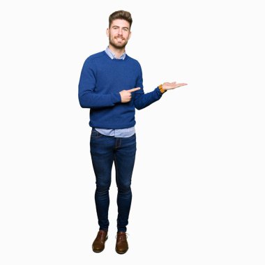 Hayret ve el ile sunulması ve parmak ile işaret ederken kameraya gülümseyen genç yakışıklı bussines adam.