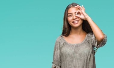 Genç güzel Arap kadın gülümsüyor, parmakları ile mutlu yüz üzerinden seyir göz el ile ok jest yapıyor izole arka plan üzerinde.