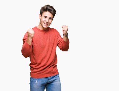 İzole arka plan kutlama üzerinde genç yakışıklı adam şaşırttı ve başarı için kaldırdı kollarını açarak hayret ve gözleri açık. Kazanan kavramı.