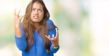 Üzerinde mavi kazak giyen genç güzel esmer kadın arka plan deli izole ve deli bağırarak ve agresif ifade ve silah kaldırdı bağırıyor. Hayal kırıklığı kavramı.