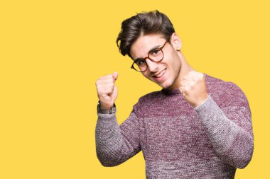 Gülümseyen ve başarı için çığlık izole arka plan çok mutlu ve heyecanlı kaldırdı, silah ile kazanan jest yapıyor üzerinde gözlük takan yakışıklı delikanlı. Kutlama kavramı.