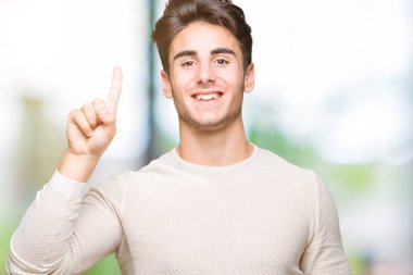 Yakışıklı delikanlı gösterilen ve kendinden emin ve mutlu gülümseyen bir parmak ile işaret eden oktan yukarı izole arka plan üzerinde.