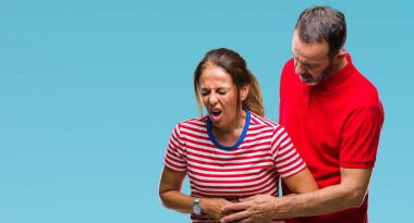 Orta yaş İspanyol çift aşık ile izole arka plan üzerinde elini karnına çünkü mide bulantısı, ağrılı hastalık hasta hissediyor. Ağrısı kavramı.