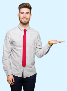 Genç yakışıklı iş adamı gülümseyen neşeli sunulması ve kameraya bakarak avucunun ile işaret.