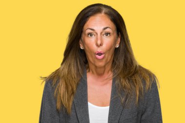 Orta yaş yetişkin kadın giyiyor büyük boy erkek ceket korkuyor ve şok sürpriz ifade ile izole arka plan üzerinde korku ve yüz heyecanlı.