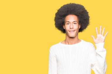 Afro saç içeren genç Afrikalı Amerikalı adam kış kazak gösteren ve parmak sayısı beş ile işaret kadar güven ve mutlu gülümseyen iken.