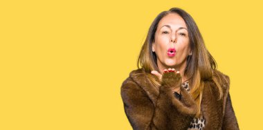 Bir öpücük el ile güzel ve seksi olmak hava üfleme kamera bakarak vizon kürk giyen güzel orta yaş zarif kadın. Aşk ifade.