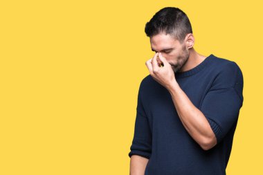 İzole arka plan üzerinde yorgun gözleri duygu yorgunluk ve baş ağrısı ve burun sürtme kazak giyen genç yakışıklı adam. Stres ve hayal kırıklığı kavramı.