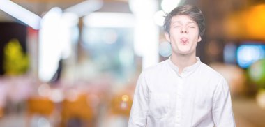 Genç yakışıklı iş adamı dilini izole arka plan üzerinde out komik ifade ile mutlu. Duygu kavramı.