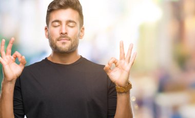 Yakışıklı delikanlı izole arka plan üzerinde dinlenmek ve gülümseyen gözlerle parmak ile meditasyon jest yapıyor kapalı. Yoga kavramı.