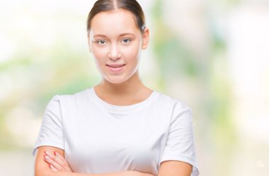 İzole arka plan mutlu yüz çapraz silah kameraya bakarak ile gülümseyen genç güzel beyaz kadın. Olumlu bir kişi.