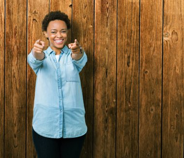 Genç güzel Afrikalı-Amerikalı kadın yüzünden izole arka plan size işaret ve parmaklar, kamerayla olumlu ve neşeli gülümseyen