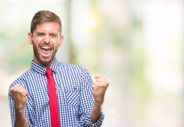 Gülümseyen ve başarı için çığlık genç yakışıklı iş adamı izole arka plan çok mutlu ve heyecanlı kaldırdı, silah ile kazanan jest yapıyor üzerinde. Kutlama kavramı.