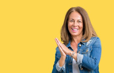 Casual denim ceket izole üzerinde giyen güzel orta yaş kadın arka plan Clapping ve mutlu ve neşeli, gururlu gülümseyen birlikte eller alkış