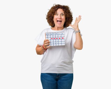 Adet takvim tutan orta ager üst düzey kadın büyük gülümseme ile çığlık zaferini kutluyor ve ellerini kaldırdı arka plan çok mutlu ve heyecanlı, kazanan ifade izole