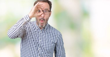 Sürpriz yüz, göz parmaklarının arasından seyir ile ok jest yapıyor izole arka plan üzerinde gözlük takan yakışıklı orta yaş zarif komuta sizde şok. İmansız ifade.