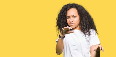 Casual beyaz t-shirt giyen kıvırcık saçlı Genç güzel kız tiksinti ifadesi, memnun ve korkulu tiksinti yüz yapıyorsun çünkü nefret tepki. Elleriyle kaldırdı. Sinir bozucu kavramı.