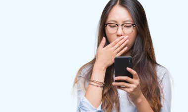 Genç Asyalı kadın manifatura için hata, korku, ifade izole arka kapak ağız utanç ile şok el ile üzerinden Smartphone kullanarak sessizlik içinde gizli kavramı korkuttu