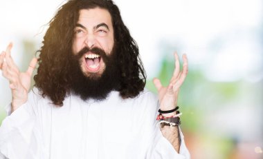 İsa Mesih giyen adam çılgın ve kızgın bağırarak ve agresif ifade ve silah kaldırdı bağırmaya kostüm. Hayal kırıklığı kavramı.