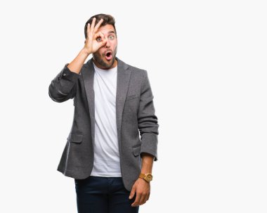 Genç yakışıklı iş adamı ok jest yapıyor izole arka plan üzerinde sürpriz yüz, göz parmaklarının arasından seyir ile şok. İmansız ifade.