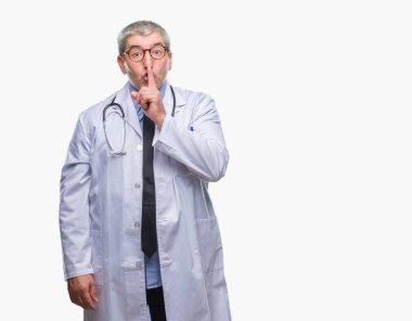Dudaklarında parmak ile sessiz olmanı izole arka plan yakışıklı kıdemli Doktor adam. Sessizlik ve gizli kavramı.