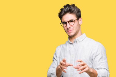Yakışıklı delikanlı izole arka plan üzerinde gözlük tiksinti ifadesi, memnun ve korkulu tiksinti yüz yapıyorsun çünkü nefret tepki. Elleriyle kaldırdı. Sinir bozucu kavramı.