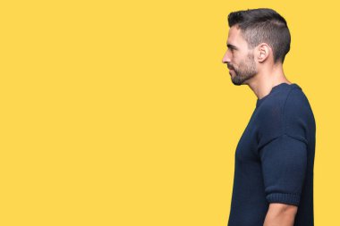 Genç yakışıklı adam giyen kazak izole arka tarafına, seyir üzerinde dinlenmek doğal yüz emin gülümseme ile pozuyla profili.