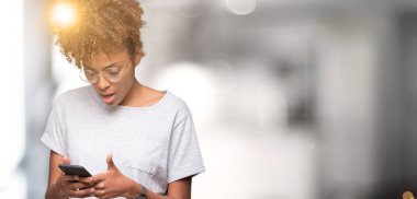 İzole arka şok sürpriz yüzü, korkuyor ve korku ifadesi ile heyecanlı olan korkmuş üzerinde akıllı telefon kullanan genç Afro-Amerikan kadın