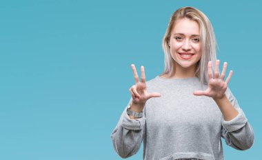 Genç Sarışın kadın gösterilen ve parmakları ile işaret izole arka plan yüzünden kendinden emin ve mutlu gülümseyerek süre 8 numaralı.