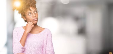 Güzel genç Afro-Amerikan kadın gözlük ile izole arka plan üzerinde çene düşünme hakkında soru, dalgın ifade ver. Düşünceli yüzüyle gülümsüyor. Şüphe kavramı.