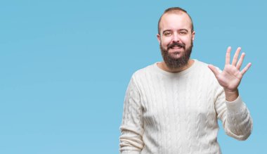 Gösterilen arka plan üzerinde kış kazak giyen genç beyaz hipster adam izole ve parmakları ile işaret kendinden emin ve mutlu gülümseyerek süre beş numara.