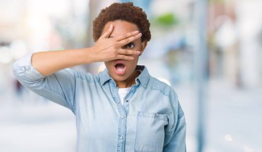 Yüz ve gözler el ile kapsayan şok bakmak izole arka plan üzerinde genç güzel Afrikalı-Amerikalı kadın mahcup ifadeyle parmaklarımın arasından arıyorsunuz.