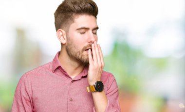 Casual adam esniyor sıkılmış genç yakışıklı iş kapsayan ağız el ile yorgun. Restless ve uyku hali.