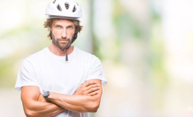 Üzerinde güvenlik kask giymiş yakışıklı İspanyol bisikletçi adam arka plan şüpheci izole ve gergin, ifade ile yüzünde onaylamayan silah geçti. Negatif kişi.