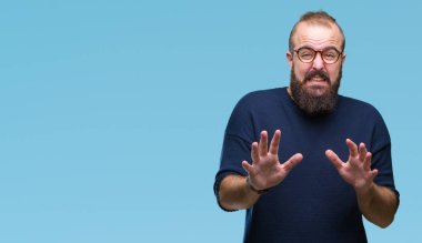 Güneş gözlüğü izole arka plan üzerinde giyen genç beyaz hipster adam tiksinti ifadesi, memnun ve korkulu tiksinti yüz yapıyorsun çünkü nefret tepki. Elleriyle kaldırdı. Sinir bozucu kavramı.