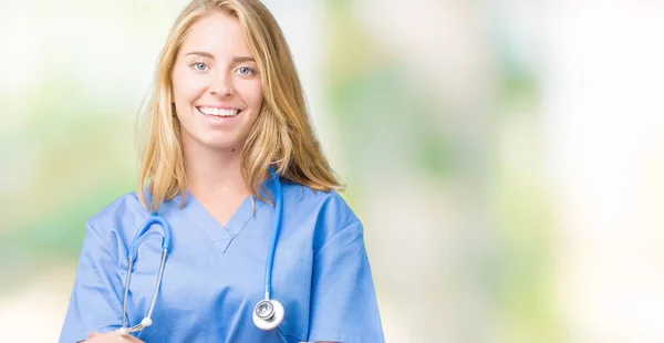 美丽的年轻医生妇女穿着医疗制服在孤立的背景快乐的脸微笑着交叉的手臂看着镜头 积极的人 — 图库照片
