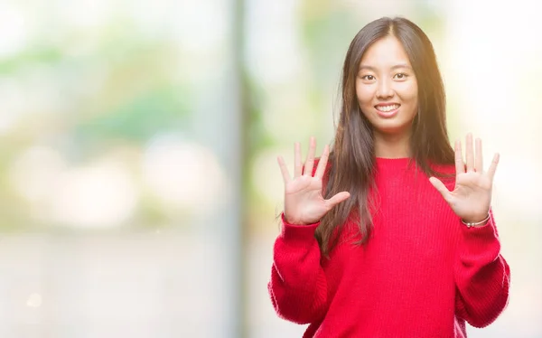 年轻的亚洲妇女穿着冬季毛衣在孤立的背景显示和指向与手指数字十同时微笑自信和快乐 — 图库照片
