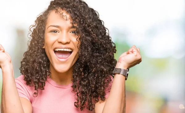 Joven Mujer Hermosa Con Pelo Rizado Usando Camiseta Rosa Celebrando — Foto de Stock