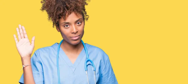 Jonge Afro Amerikaanse Dokter Vrouw Geïsoleerde Achtergrond Afzien Zeggen Hallo — Stockfoto