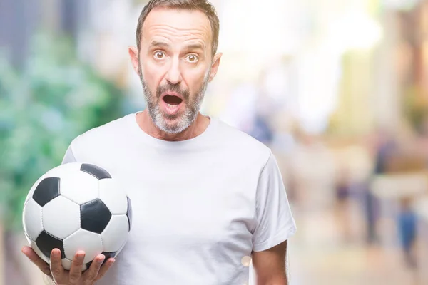 驚き顔 恐怖表現と興奮とショックで怖いの孤立した背景にサッカー サッカー ボールを保持している 中年の白髪年配の男性 — ストック写真