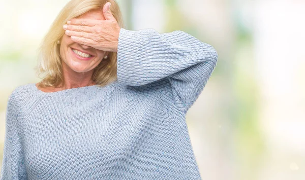 中年微笑し 笑う顔驚きの目を覆っている手で孤立した背景に冬のセーターを着ている金髪の女性 視覚障害者の概念 — ストック写真