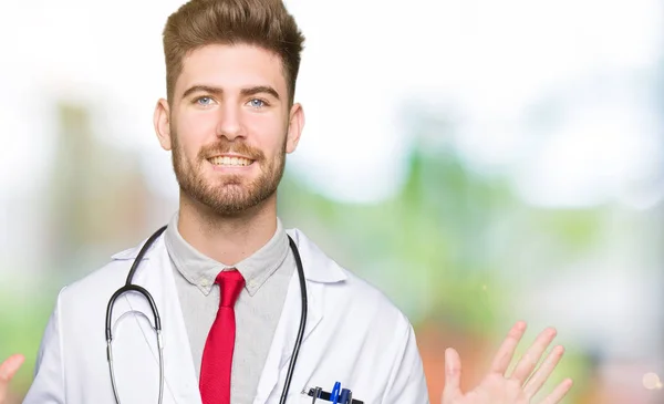 年轻英俊的医生男子穿着医疗外套显示和手指指向十 而微笑着自信和快乐 — 图库照片